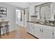Charming kitchen with white cabinets, stainless steel sink, and a view into the entryway at 714 E Michigan Ave, Deland, FL 32724