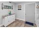Entryway with a white dresser, hardwood floors, a 'welcome' sign, and a view into the adjacent kitchen at 1640 Juno Trl # 205A, Astor, FL 32102