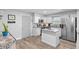 Updated kitchen featuring white cabinets, stainless steel appliances, granite countertops, and light, wood-look flooring at 1640 Juno Trl # 205A, Astor, FL 32102