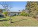 Ranch home with a spacious front yard, lush landscaping, and a tree at 4430 Doris Dr, New Smyrna Beach, FL 32169