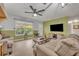 Bright living room with large windows, ceiling fan, and neutral decor at 4430 Doris Dr, New Smyrna Beach, FL 32169