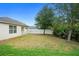 A backyard with a white fence, tree, and green area offers a peaceful outdoor setting at 2924 Taton Trce, New Smyrna Beach, FL 32168