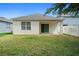 Backyard featuring an outdoor patio area, sliding glass doors, and a well-maintained lawn at 2924 Taton Trce, New Smyrna Beach, FL 32168