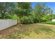 Backyard featuring lush greenery and a white fence, creating a serene outdoor space at 2924 Taton Trce, New Smyrna Beach, FL 32168