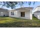 The backyard features a well-maintained lawn and a sliding glass door to the covered patio at 2924 Taton Trce, New Smyrna Beach, FL 32168