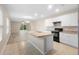 Open kitchen features an island, white cabinets, and a view into the living area at 2924 Taton Trce, New Smyrna Beach, FL 32168