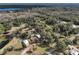 Wide aerial view of a wooded property featuring several small structures and nearby lake at 353 Vannote Rd, Pierson, FL 32180