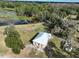 Aerial view of a small home with a light metal roof surrounded by lush greenery and a pond at 353 Vannote Rd, Pierson, FL 32180