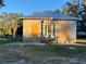 Exterior view of home featuring concrete block construction, a metal roof, and boarded windows at 353 Vannote Rd, Pierson, FL 32180