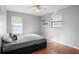 Cozy bedroom features a ceiling fan, natural light from windows, and warm wood-look flooring at 1195 Glen Royal Ter, Deland, FL 32720