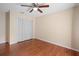 Bedroom with hardwood floors and a ceiling fan, featuring a closet with bi-fold doors at 1195 Glen Royal Ter, Deland, FL 32720