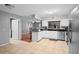 Spacious kitchen with white cabinetry, tiled flooring, black countertop, and stainless steel appliances at 1195 Glen Royal Ter, Deland, FL 32720