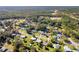 A scenic aerial shot of a neighborhood showcasing lush greenery, interspersed homes and a dense forest backdrop at 1437 Colin Kelly Ave, Daytona Beach, FL 32124