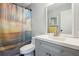 This bathroom features a single vanity with a white countertop and blue cabinets, complemented by a shower with an ocean-themed curtain at 1437 Colin Kelly Ave, Daytona Beach, FL 32124