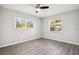 Bright bedroom with wood-look floors, two windows offering natural light, and neutral walls creating a serene atmosphere at 1437 Colin Kelly Ave, Daytona Beach, FL 32124