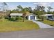 Charming one-story home with a one-car garage, lush lawn, and mature palm tree landscaping at 1437 Colin Kelly Ave, Daytona Beach, FL 32124