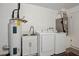 Functional laundry area with modern washer and dryer, utility sink, and water heater for added convenience at 1437 Colin Kelly Ave, Daytona Beach, FL 32124