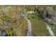 Aerial view of home and property surrounded by mature trees and open space at 227 N Putnam Grove Rd, Oak Hill, FL 32759