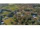 Overhead view of a serene property with dense woods and a private pond, set amongst picturesque farmland and serene nature at 227 N Putnam Grove Rd, Oak Hill, FL 32759