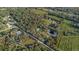 Sweeping aerial shot of an estate nestled among woodlands and orchards, with tranquil ponds adding to the serene landscape at 227 N Putnam Grove Rd, Oak Hill, FL 32759