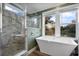 Spa bathroom featuring a walk-in shower, freestanding soaking tub, and windows that overlook an outside landscape at 227 N Putnam Grove Rd, Oak Hill, FL 32759