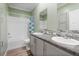 Bright bathroom features a double sink vanity, tile backsplash, and shower-tub combination at 227 N Putnam Grove Rd, Oak Hill, FL 32759