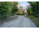 Gated driveway entrance offering privacy and security amidst a natural setting, inviting exploration and serenity at 227 N Putnam Grove Rd, Oak Hill, FL 32759