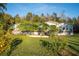 A home exterior featuring a well-maintained lawn, mature landscaping, and a charming front porch at 227 N Putnam Grove Rd, Oak Hill, FL 32759