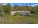 Exterior shot of a charming home, with lush green lawn and mature trees surrounding at 227 N Putnam Grove Rd, Oak Hill, FL 32759