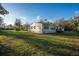 Manufactured home on a large lot with lush green grass and mature trees at 227 N Putnam Grove Rd, Oak Hill, FL 32759
