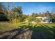 Lovely home exterior with green lawn and mature trees creating a peaceful and private atmosphere at 227 N Putnam Grove Rd, Oak Hill, FL 32759