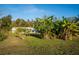 Beautiful home exterior surrounded by banana trees and lush greenery, offering a tropical feel at 227 N Putnam Grove Rd, Oak Hill, FL 32759