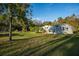 Charming home with a large lawn surrounded by lush trees, offering a serene and private setting at 227 N Putnam Grove Rd, Oak Hill, FL 32759
