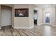 Foyer with beautiful artwork, interior doors, an exterior door with glass, and wood-look floors at 227 N Putnam Grove Rd, Oak Hill, FL 32759