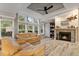 Bright living room featuring a fireplace, large windows, and a comfortable leather sofa at 227 N Putnam Grove Rd, Oak Hill, FL 32759