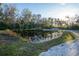 Scenic view of a pond with natural surroundings and reflective water, enhancing the property's tranquility at 227 N Putnam Grove Rd, Oak Hill, FL 32759
