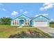 Charming, single-story blue home featuring an attached two-car garage and bright, welcoming curb appeal at 3190 Lori Ct, Deltona, FL 32738