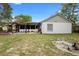 Well-maintained backyard with pergola-covered patio and mature trees at 1083 E Normandy Blvd, Deltona, FL 32725