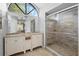 Bathroom featuring dual vanities, a walk-in shower, and a large arched window at 1083 E Normandy Blvd, Deltona, FL 32725