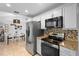 Updated kitchen with stainless appliances, granite counters, and adjacent dining area at 1083 E Normandy Blvd, Deltona, FL 32725