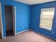 Blue-walled bedroom with carpet flooring and a closet at 1201 Buccaneer Ave, Deltona, FL 32725