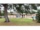 Tan house with a large tree in the front yard and a two-car garage at 1201 Buccaneer Ave, Deltona, FL 32725