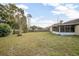 Fenced backyard with grassy area and mature trees at 1267 Saxon Blvd, Deltona, FL 32725