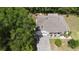 A serene aerial view of a single-Gathering home with a paved driveway and a gray roof amidst lush greenery at 1600 Lady Fern Trl, Deland, FL 32720