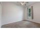 Neutral-toned bedroom features plush carpet, ceiling fan, closet, and a sunlit window at 1600 Lady Fern Trl, Deland, FL 32720