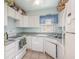 Efficient kitchen featuring white cabinets, appliances, and a window above the sink at 225 N Hill Ave # 60, Deland, FL 32724