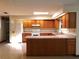 A bright kitchen with wooden cabinets, tile floors, an island and modern appliances at 641 Fairhaven St, Deltona, FL 32725