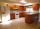 A bright kitchen with wooden cabinets, tile floors, an island and modern appliances at 641 Fairhaven St, Deltona, FL 32725