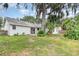 Spacious backyard with green grass, mature trees, and patio at 779 Victoria E Cir, Ormond Beach, FL 32174