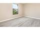 Bright bedroom with modern flooring, neutral walls, and a window overlooking lush greenery at 779 Victoria E Cir, Ormond Beach, FL 32174